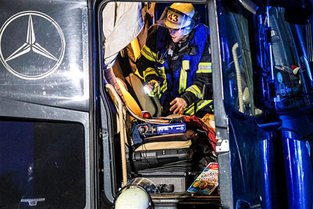 Ein Feuerwehrmann untersucht die Fahrerkabine eines Lastwagens auf der Autobahn 1 bei Hagen
