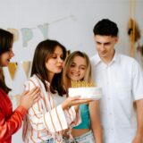 3 Mädchen und ein Junge feiern einen 18. Geburtstag mit einer Geburtstagstorte