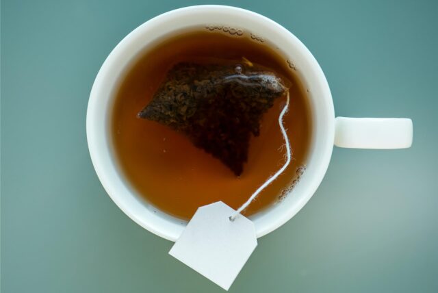 Ein Teebeutel hängt in einer Tasse.