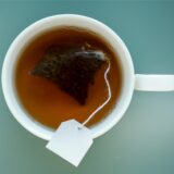 Ein Teebeutel hängt in einer Tasse.