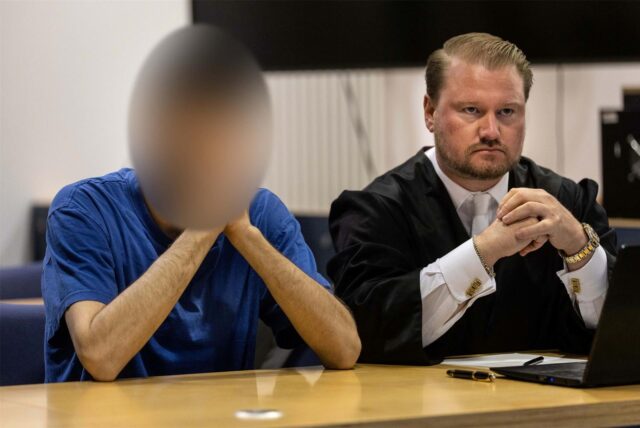 Der 24-jährige Angeklagte (l), der in Menden eine 17-Jährige mit Benzin übergossen und angezündet haben soll, sitzt zu Prozessbeginn im Landgericht neben Rechtsanwalt Nils Schiering.