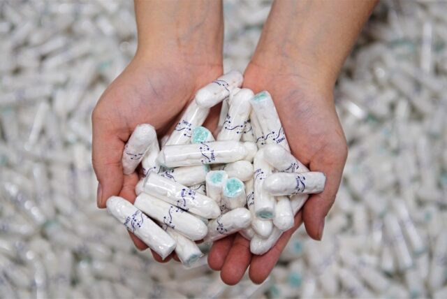 Zwei Hände halten Tampons.