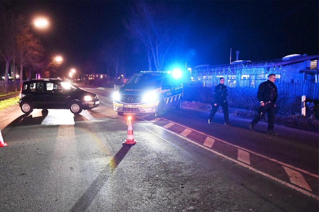 Polizeifahrzeuge sperren eine Straße ab. Polizeifahrzeuge sperren eine Straße ab.