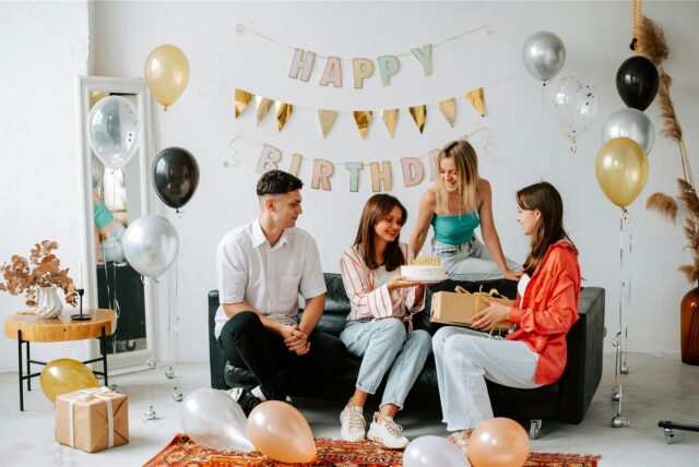 Ein Mann und drei Frauen sitzen auf der Couch und gratulieren zum 30. Geburtstag.