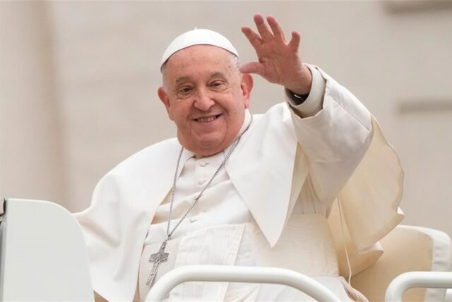 Papst Franziskus lächelt und winkt.
