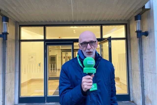 HA-Redakteur Joachim Schmidt steht vor dem Hertener Rathaus mit einem Mikrofon in der Hand.