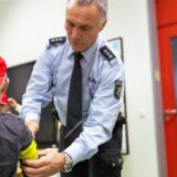 Ein Polizist der Kreispolizeibehörde in Recklinghausen legt einem Schulkind eine Leuchtbinde an.
