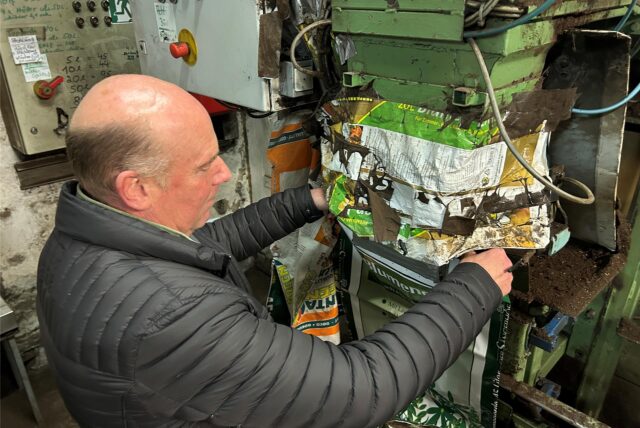 Udo Kuhlmann hält einen Plastiksack unter die Abfüllmaschine.
