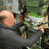 Udo Kuhlmann hält einen Plastiksack unter die Abfüllmaschine.