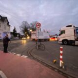 Ein Polizist steht an einer Kreuzung und nimmt einen Unfall auf.
