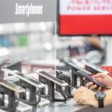 Kunden schauen sich in einer Media Markt Filiale die neuesten Smartphones in der Auslage an