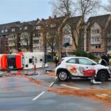 Ein Rettungswagen liegt in Mülheim an der Ruhr auf der Seite, ein kleines Lieferantenauto steht daneben. Betriebsstoffe sind ausgelaufen.