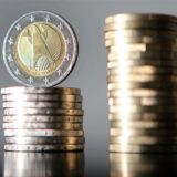 Zwei Münzstapel, auf einem steht eine Euro-Münze.