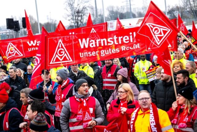 Streikende stehen vor dem Volkswagen-Werk Emden.