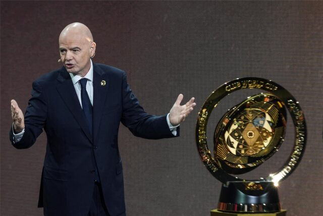 Gianni Infantino steht neben einem Pokal.