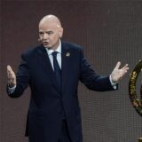 Gianni Infantino steht neben einem Pokal.