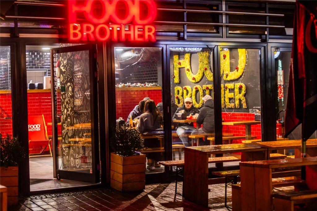 Junge Leute sitzen bei Food Brother an der Brückstraße in Dortmund.