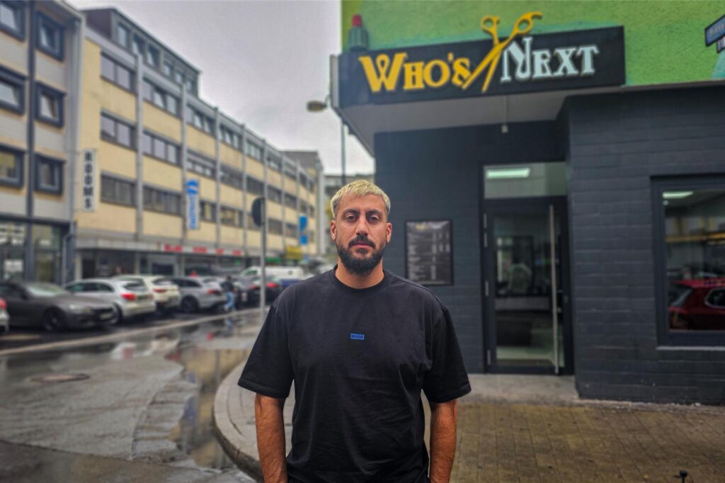 Betreiber Yasser steht vor seinem Friseursalon 