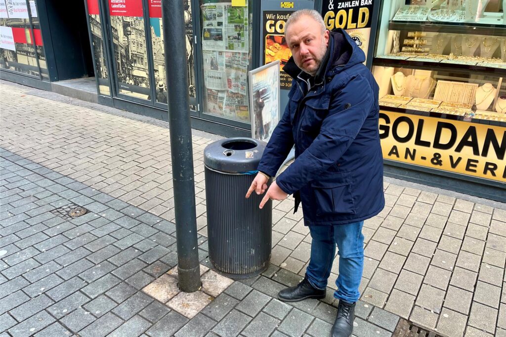 Isa Dalmann zeigt auf eine dreckige Stelle auf der Brückstraße in Dortmund.
