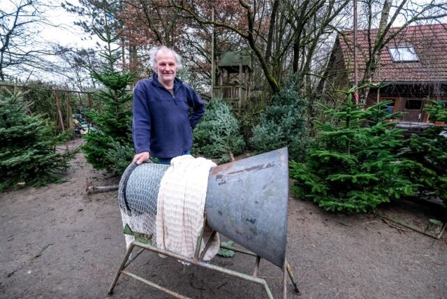 Ein Mann in blauem Pullover steht auf einem Hof. Vor ihm ist ein grauer Trichter, hinter ihm stehen Tannen. (Archiv)