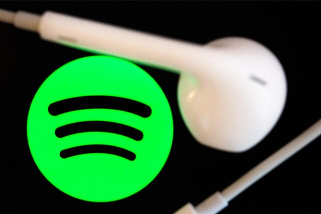 Symbolbild: Das grüne Logo des Streaming-Dienstes Spotify, daneben ein weißer Kopfhörer.