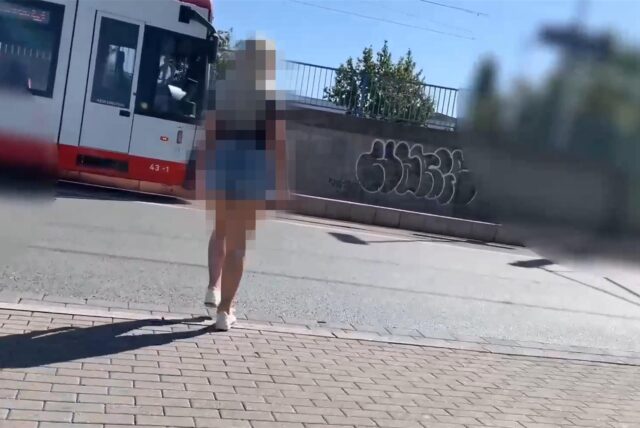 Eine Pornodarstellerin geht über den Wickeder Hellweg in Dortmund zu einer Stadtbahn der Linie U43.