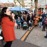 Sängerin Malin Lewis steht beim Wintertreff in der Hertener Innenstadt auf der Bühne, vor der viele Männer und Frauen stehen und zuhören.