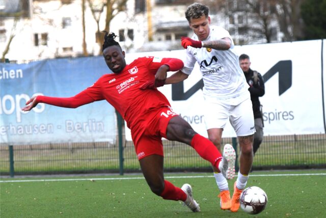 Ein Spieler von Wiemelhausen versucht per Grätsche, einem Erkenschwicker Spieler den Ball abzunehmen.