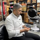 Gespannt blickt der gebürtige Syrer Ahmad Shbat auf sein Handy. Er sitzt in seinem Friseursalon in Schwerte.