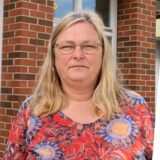 Claudia Ferdinand steht vor dem Pavillon der Hertener Allgemeinen in der Herrmann Straße. Im Hintergrund ist die Auslage von Kodi zu sehen.