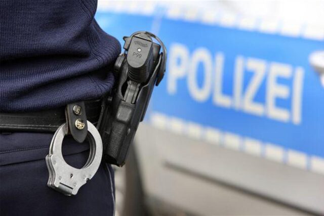 Polizist mit Waffe und Handschellen