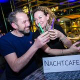 Zwei Besucher stoßen mit ihren Getränken auf einer Nachtcafe-Party in Recklinghausen an