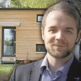 Die Kombo zeigt Bürgermeister Mittelbach vor einem „Tiny House“