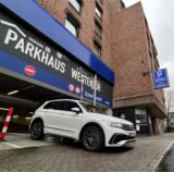 Links fährt ein Auto aus dem Parkhaus Westentor in Dortmund, rechs Dopark-Geschäftsführer Simon Kinz.