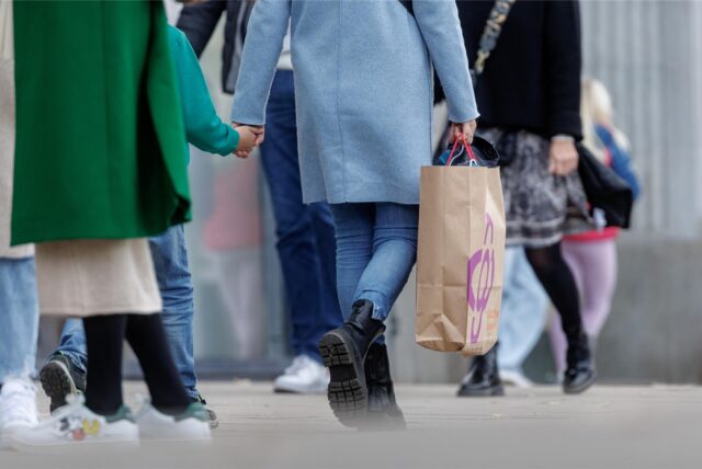 Eine Besucherin des verkaufsoffenen Sonntags geht mit ihrer Einkaufstasche durch die Innenstadt.