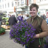 Blumenhändlerin Melanie Jentsch hält beim Blumen- und Kreativmarkt in Herten einen lilafarbenen Strauß aus Blumen in der Hand.
