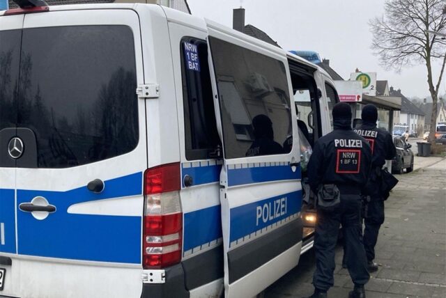 Polizeibeamte stehen neben einem Mannschaftswagen in Oer-Erkenschwick.