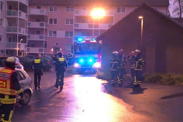 Einsatzkräfte der Feuerwehr stehen nach einem Brand am Einsatzort.
