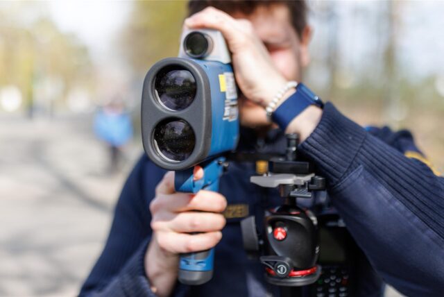 Ein Polizist führt Geschwindigkeitsmessungen mit einem Laser durch