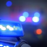 Ein Polizeiauto mit eingeschaltetem Blaulicht steht an einer Unfallstelle.