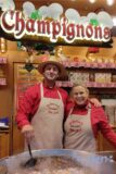 Jessica (51) und Erich (54) Winter sind seit 30 Jahren auf dem Dortmunder Weihnachtsmarkt unterwegs. Los ging es mit einem Stand für Muscheln, Fischsuppe und diversen Weinen. Darauf folgte mangels ordentlicher Nachfrage einen Maronenstand. Darauf 2013 der Champignons-Stand. Zwischenzeitlich erweitert um gebratenen Blumenkohl und Maiskolben. Die Besucher wissen das Angebot zu schätzen. Schließlich schmeckt beim „Mann mit dem Hut alles gut“. So steht es zumindest auf den Schürzen.