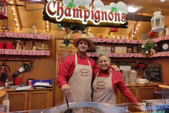 Jessica (51) und Erich (54) Winter sind seit 30 Jahren auf dem Dortmunder Weihnachtsmarkt unterwegs. Los ging es mit einem Stand für Muscheln, Fischsuppe und diversen Weinen. Darauf folgte mangels ordentlicher Nachfrage einen Maronenstand. Darauf 2013 der Champignons-Stand. Zwischenzeitlich erweitert um gebratenen Blumenkohl und Maiskolben. Die Besucher wissen das Angebot zu schätzen. Schließlich schmeckt beim „Mann mit dem Hut alles gut“. So steht es zumindest auf den Schürzen.