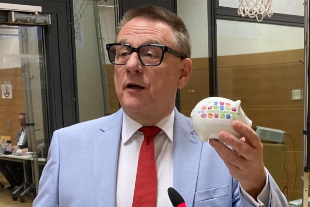 Der SPD-Fraktionschef Peter Wenzel hält ein Sparschwein in der Hand
