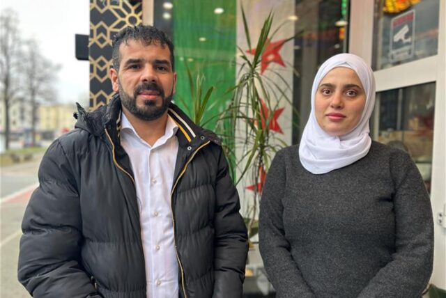 Adnan Al Hlke und Rawan Abdalhafez stehen in Marl vor einer syrischen Flagge.