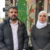 Adnan Al Hlke und Rawan Abdalhafez stehen in Marl vor einer syrischen Flagge.