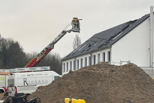 Eine ausgefahrene Drehleiter der Feuerwehr steht vor einem Haus im Neubaugebiet Kirschgärten in Recklinghausen, in dem ein Brand ausgebrochen war.