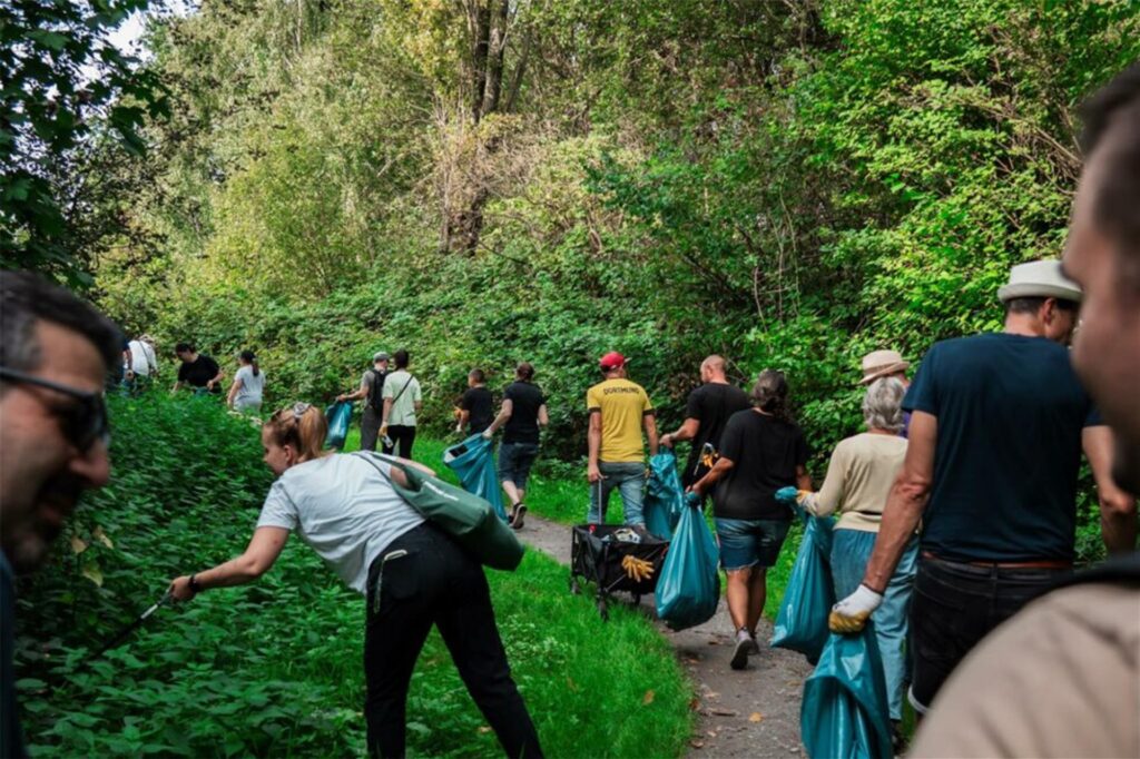 Große Müllsammelaktion am World Clean Up Day in Merklinde. Eine Gruppe aus mindestens einem Dutzend Menschen sammelt Abfall im Wald ein und wirft ihn in mitgebrachte Müllsäcke. Große Müllsammelaktion am World Clean Up Day in Merklinde. Eine Gruppe aus mindestens einem Dutzend Menschen sammelt Abfall im Wald ein und wirft ihn in mitgebrachte Müllsäcke.