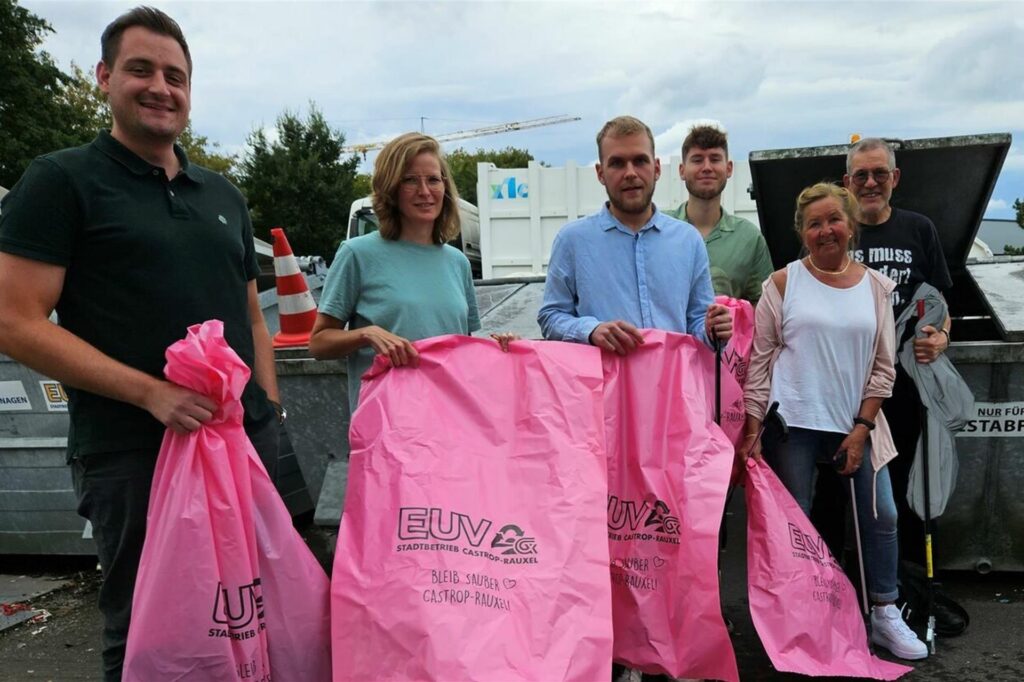 Bei einer Aufräumaktion werfen Organisatoren und Teilnehmer gefundenen Abfall in pinke Müllsäcke mit der Aufschrift EUV. Bei einer Aufräumaktion werfen Organisatoren und Teilnehmer gefundenen Abfall in pinke Müllsäcke mit der Aufschrift EUV.