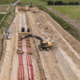 Porträt von Linus Dahn und ein Feld mit Leitungsrohren und einem Bagger