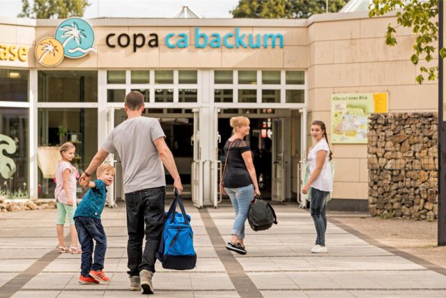 Menschen mit Taschen gehen auf den Eingang des Copa Ca Backum zu.